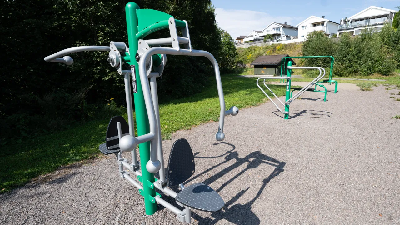 Et grønt og hvitt treningsapparat i en park.