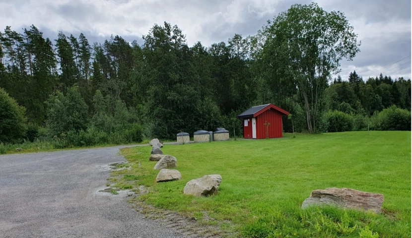 Et rødt skur på toppen av en frodig, grønn åker.