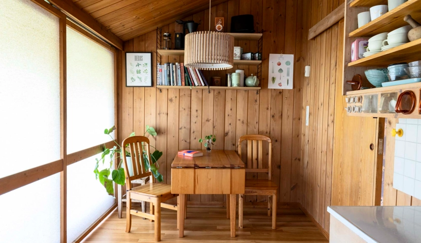 Et kjøkken med trevegger og bord og stoler.