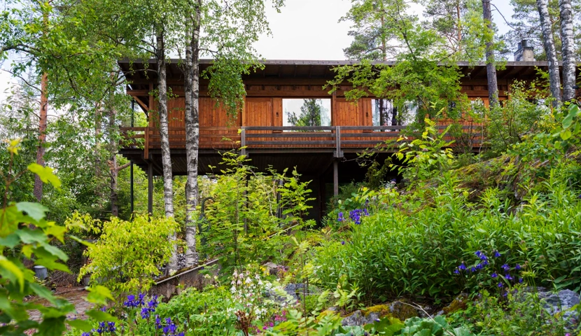 Et hus i skogen omgitt av trær.