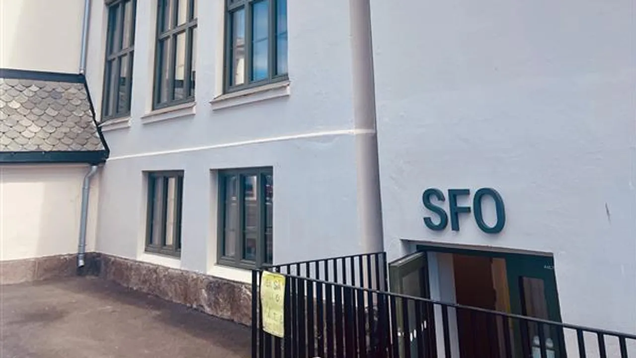 En hvit bygning med inngang til SFO i første etasje