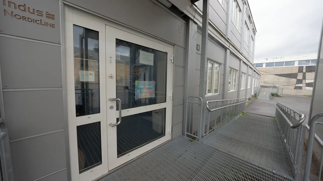 En bygning med to dører og en rampe som fører opp til den.